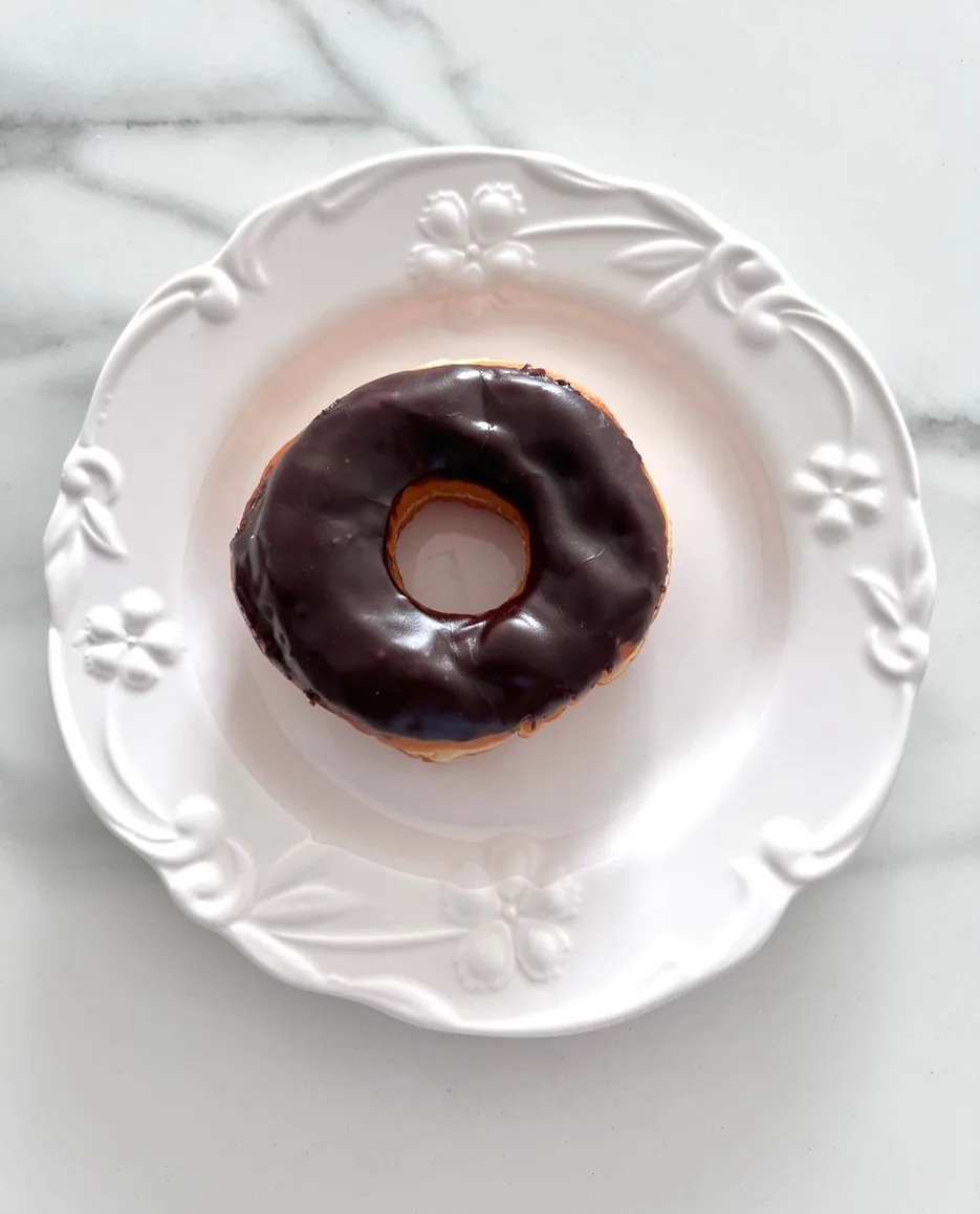 白い皿にのったチョコレートグレーズのドーナツ