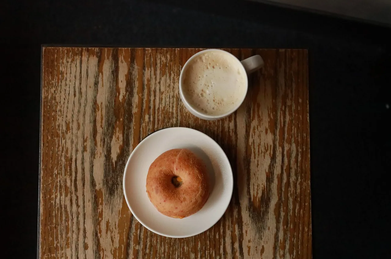 木のテーブルに置いたドーナツとコーヒー